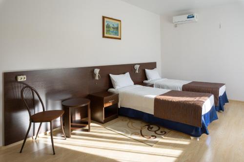 Schlafzimmer mit einem Bett, einem Tisch und Stühlen in der Unterkunft Hotel Viktorya in Stawropol