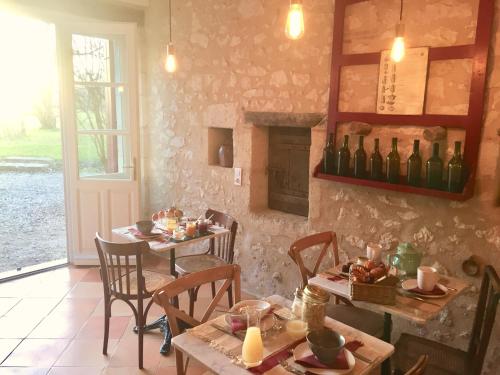 comedor con 2 mesas y chimenea en LA CARRETERIE - Maison de Famille{s}, en Pineuilh