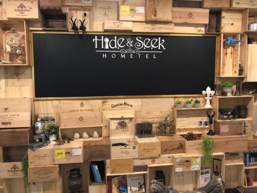 a blackboard on a wall in a store with boxes at Hide and Seek Boutique Hometel in Bangkok