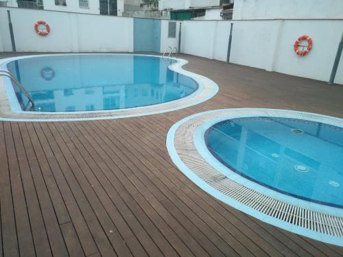 a large swimming pool on the deck of a building at Beach Apartment in Vilanova i la Geltrú
