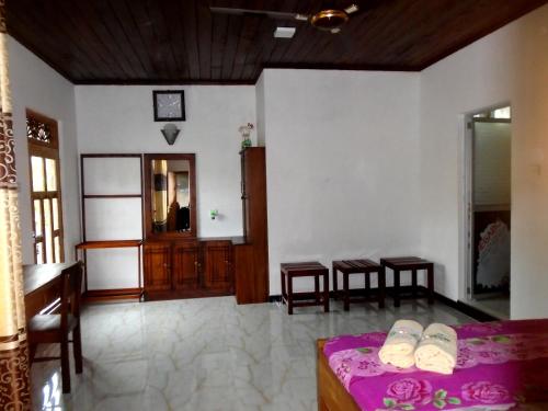 a living room with a bed and a table and chairs at Bee Line Cinnamon Estate Villa in Dickwella