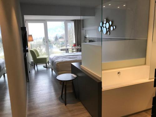 - une chambre avec un lit et un bureau avec une chaise dans l'établissement Hotel Restaurant Perle Des Vosges, à Muhlbach-sur-Munster