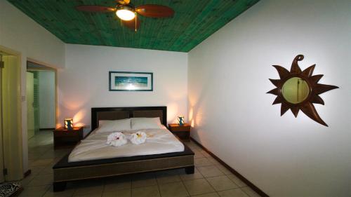 a bedroom with a bed with a sun on the wall at Takamaka Green Village in Takamaka