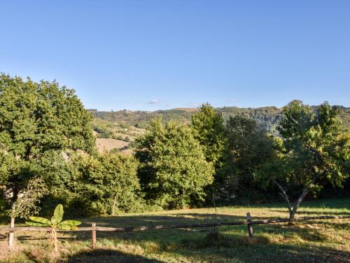 une clôture en bois dans un champ arboré dans l'établissement Comfortable holiday home with garden, à Cassaniouze