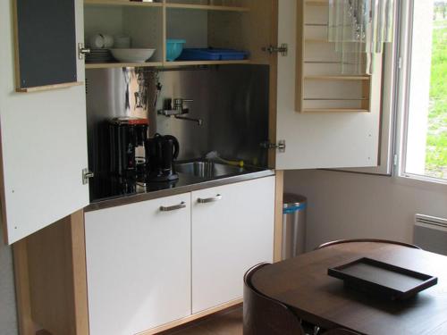 d'une cuisine avec une table, des armoires blanches et une table avec une table. dans l'établissement Poolside Apartment in Segonzac, à Segonzac