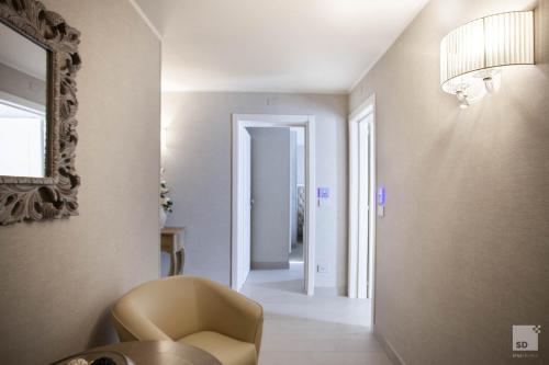 a hallway with a chair and a table and a mirror at Hotel Cavour in Bologna