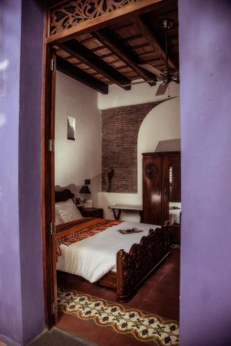a bedroom with a large bed and a large mirror at Casa de Isabella, a Kali Hotel in Santa Marta