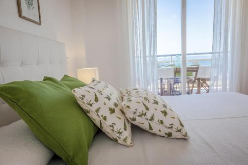 2 almohadas verdes encima de la cama en AG GALEON, en Playa de Gandía