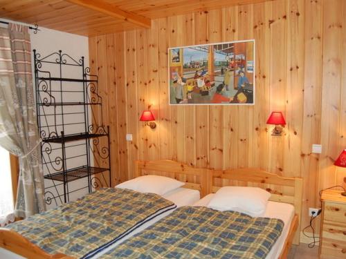 Le VillardにあるBeautiful south facing chaletのベッドルーム1室(ベッド2台付)が備わります。壁に絵が描かれています。
