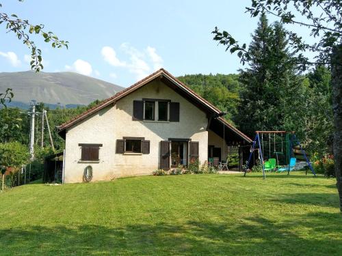a house with a playground in the yard at Chalet with mountain views in Laffrey