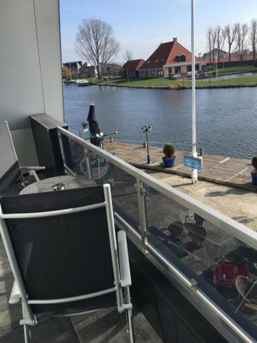 a boat with a desk and a tv on the deck at Appartementen De Helling 44 in Heeg