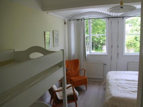 a bedroom with a bed and a chair and a window at Fjällbacka Pensionat och Vandrarhem in Fjällbacka