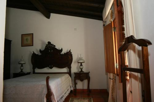 a bedroom with a bed with a wooden headboard at Quinta do Cabeçote in Cabeço de Vide