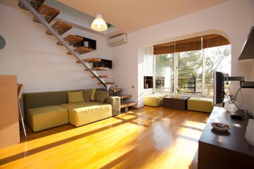 クラリェヴィツァにあるArgola Kraljevica apartmentのソファと階段のあるリビングルーム