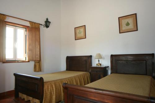a bedroom with two beds and a window at Quinta do Cabeçote in Cabeço de Vide