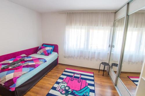- une chambre avec un lit et une valise rose dans l'établissement Mostar View, à Mostar