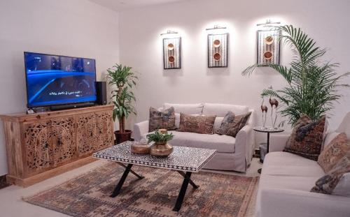 ein Wohnzimmer mit Sofa und Fernseher in der Unterkunft شقق ملفاكم للشقق المخدومة in Riad