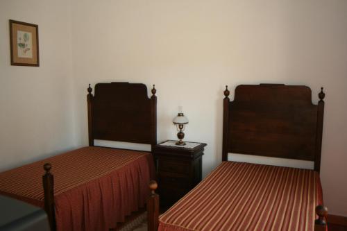 a room with two beds and a table and a lamp at Quinta do Cabeçote in Cabeço de Vide