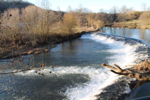 a river with rapids on the side of it at Le Moulin de Benechou in Olemps