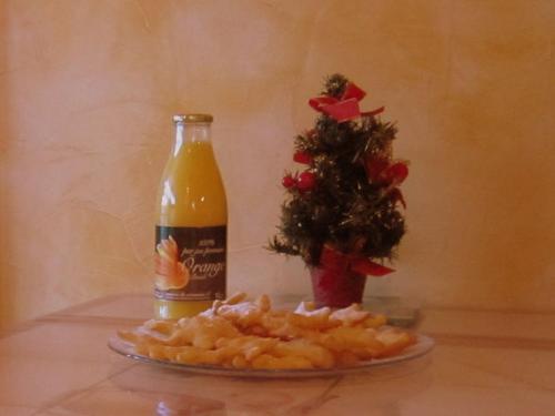 a bottle of soda next to a christmas tree and a plate of food at Cozy Cottage in Vaires sur Marne with Garden in Chelles