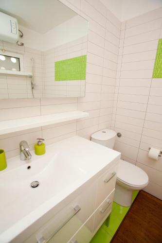 a white bathroom with a sink and a toilet at Argola Kraljevica apartment in Kraljevica