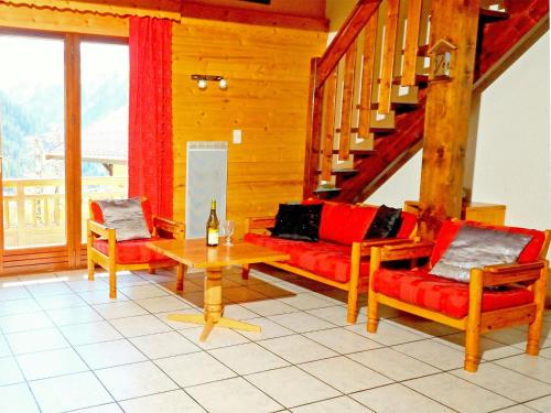 salon z czerwonymi kanapami i stołem w obiekcie Chalet in Paradiski ski area w mieście Le Villard