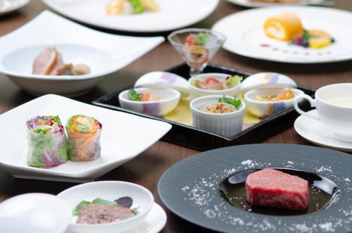 a table topped with plates of food and cups at KKR Hotel Kanazawa in Kanazawa