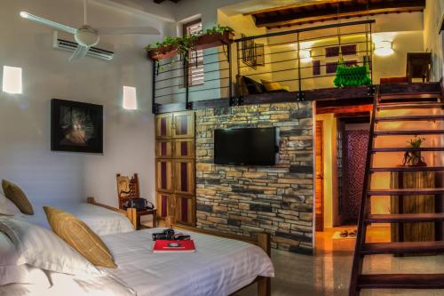 a room with two beds and a stone wall at Casa de Leda, a Kali Hotel in Santa Marta