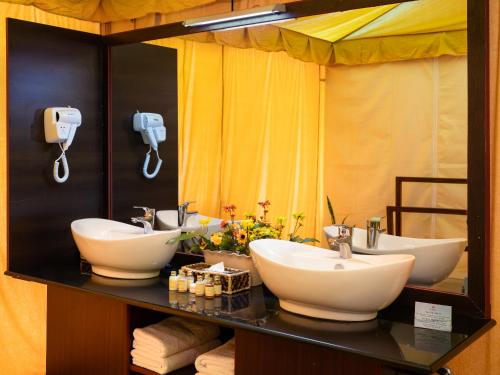 a bathroom with two sinks and a mirror at Fun Retreat Resort, Hotel and Ayurveda Spa in Arusha