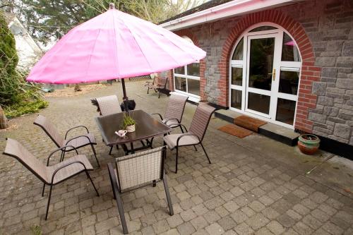 a table with a pink umbrella on a patio at Evergreen Bed & Breakfast in Swords