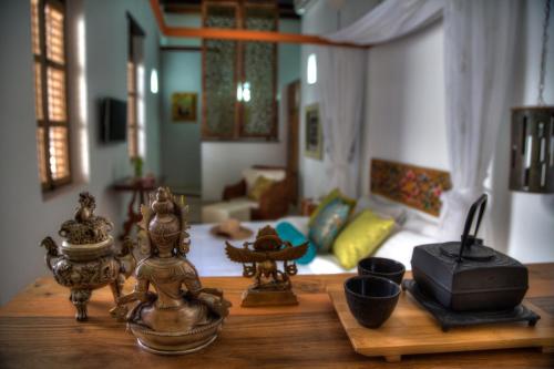 a living room with a wooden table with a room with a couch at Casa de Leda, a Kali Hotel in Santa Marta