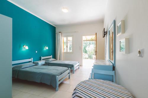 a room with three beds and blue walls at Panorama Apartments updated with infinity pool in Agios Nikolaos