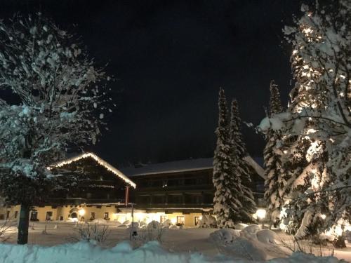 a building covered in snow at night at Hotel Unterhof in Filzmoos