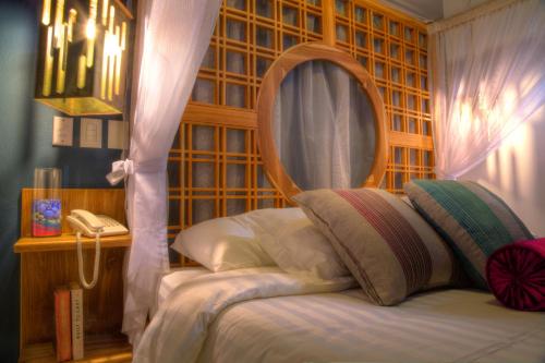 a bedroom with a bed and a phone in it at Casa de Leda, a Kali Hotel in Santa Marta