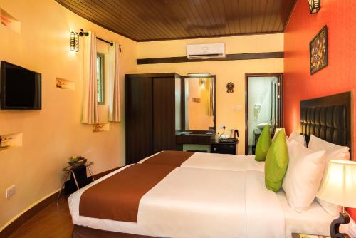 a hotel room with a large bed and a desk at Fun Retreat Resort, Hotel and Ayurveda Spa in Arusha