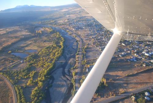 a view of a river from the wing of an airplane at Arroyo Escondido in Trevelin