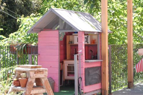 a pink play house with a stove and a ladder at Villa Giuanne in Arenzano