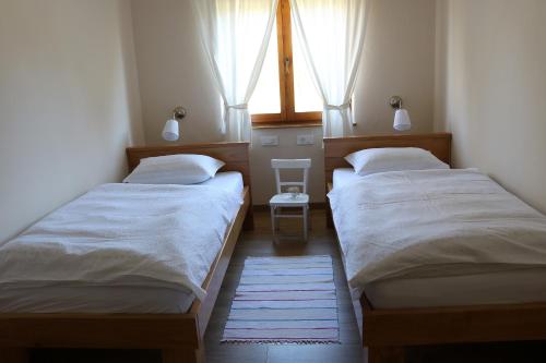 two beds in a small room with a window at The House of Dunja in Rakovica