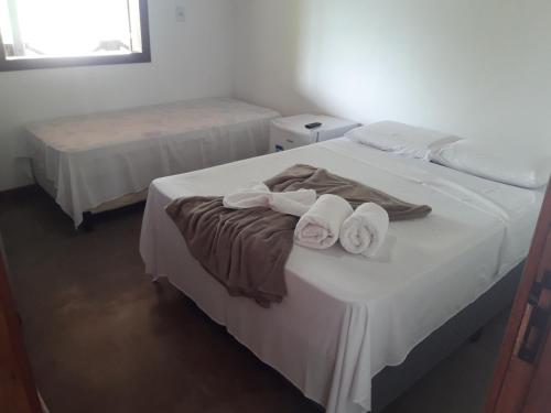 a bedroom with two beds with towels on them at Pousada Portas da Lua in Catas Altas