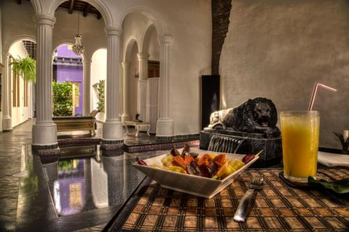 un bol de fruta en una mesa con una bebida en Casa de Leda, a Kali Hotel, en Santa Marta