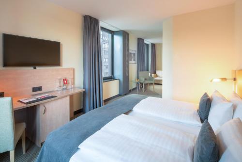 a hotel room with a bed and a television at IntercityHotel Hamburg Hauptbahnhof in Hamburg