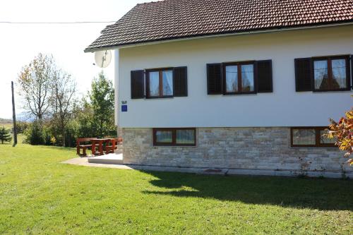 a building with black windows and a grass yard at The House of Dunja in Rakovica
