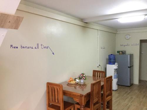 a dining room with a table and chairs and a refrigerator at Siriwal Guesthouse in Phra Nakhon Si Ayutthaya