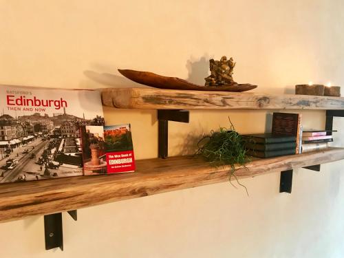 a wooden shelf on a wall with books at Grassmarket Old Town Boutique Apartment in Edinburgh