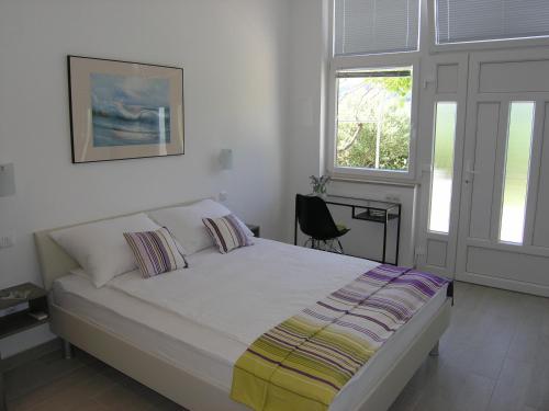 a bedroom with a bed and two windows at Apartments GORDANA Baska for relaxing holidays in Baška