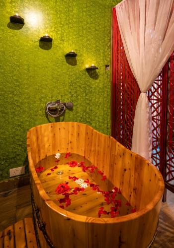 a wooden tub filled with red flowers in a bathroom at Fun Retreat Resort, Hotel and Ayurveda Spa in Arusha