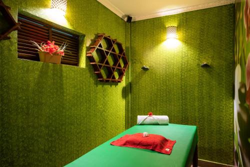 a green room with a green table with a red towel at Fun Retreat Resort, Hotel and Ayurveda Spa in Arusha