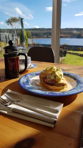 a plate of pancakes on a table with a view of the water at Airanloch, Loch Ness, Adult Only in Lochend