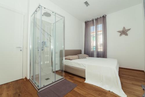 a bedroom with a glass shower and a bed at Home Diano Marina in Diano Marina