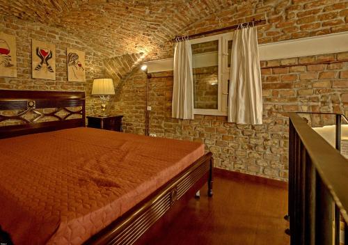een slaapkamer met een bed en een bakstenen muur bij Vinodorum Apartments in Cluj-Napoca